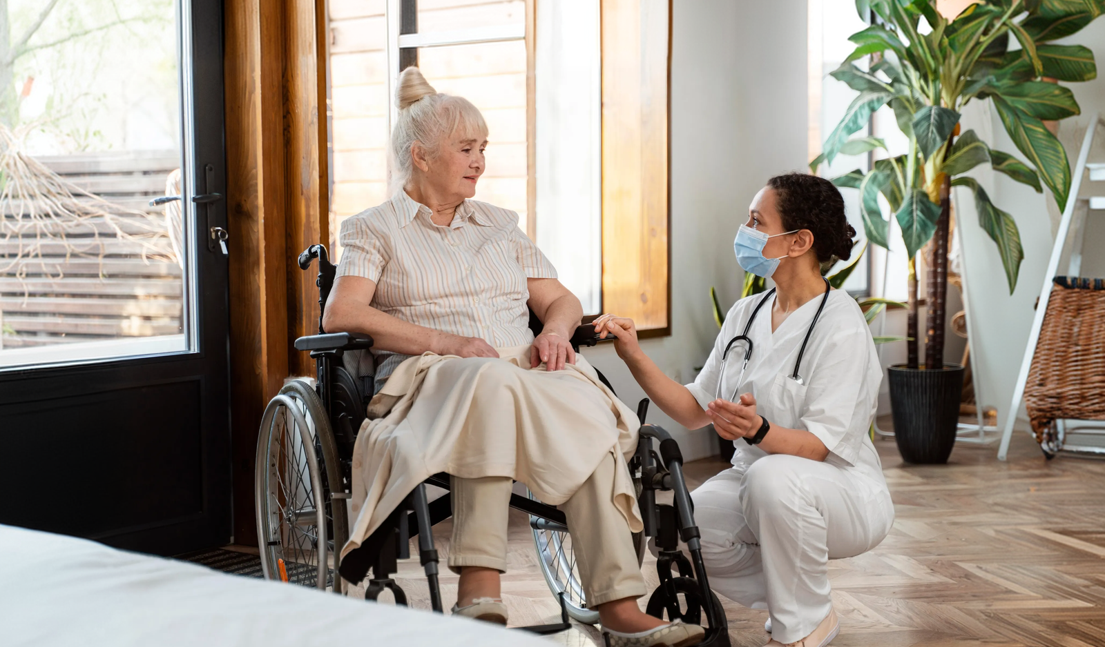 Caregiver supporting senior woman in wheelchair
